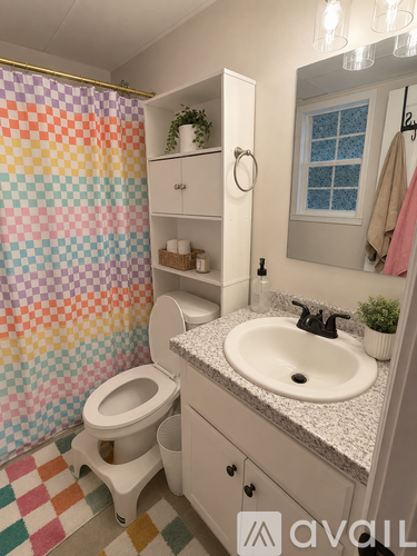 A bathroom with a toilet, sink, and a shower curtain.