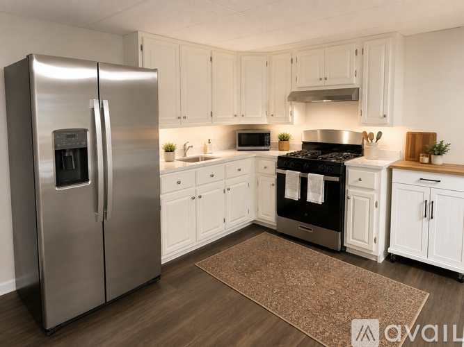 A modern kitchen with a stainless steel refrigerator and black stove top oven.