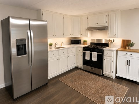 A modern kitchen with a stainless steel refrigerator and black stove top oven.