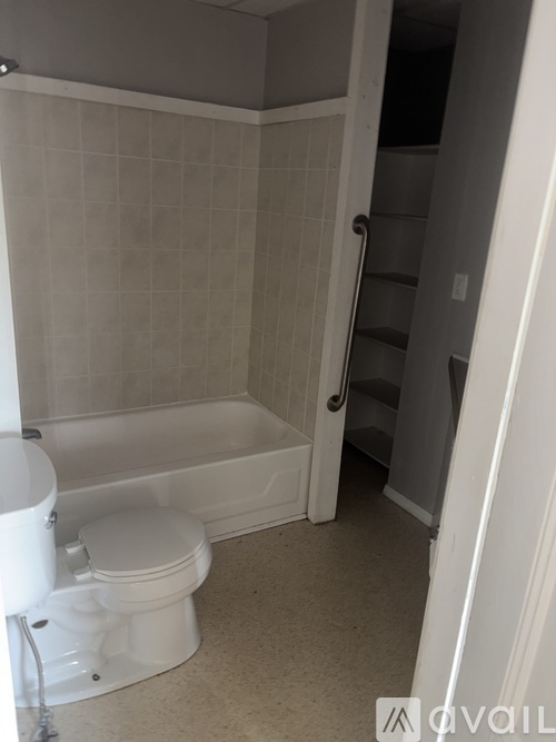 A white toilet is next to a bathtub in a bathroom.
