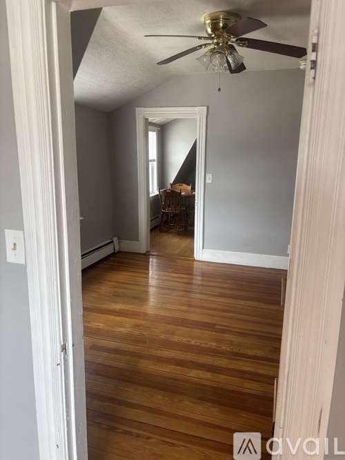A room with wooden floors and a ceiling fan.