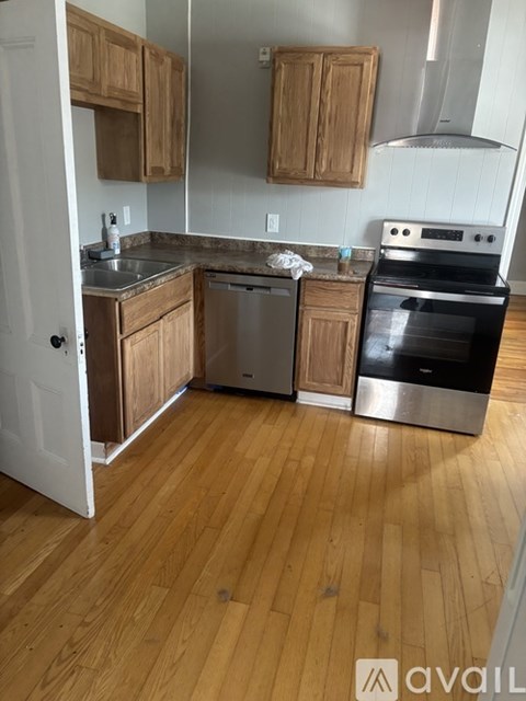 A kitchen with wooden cabinets and a stainless steel oven.