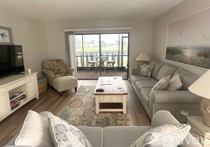 A living room with a couch, chair, and television.