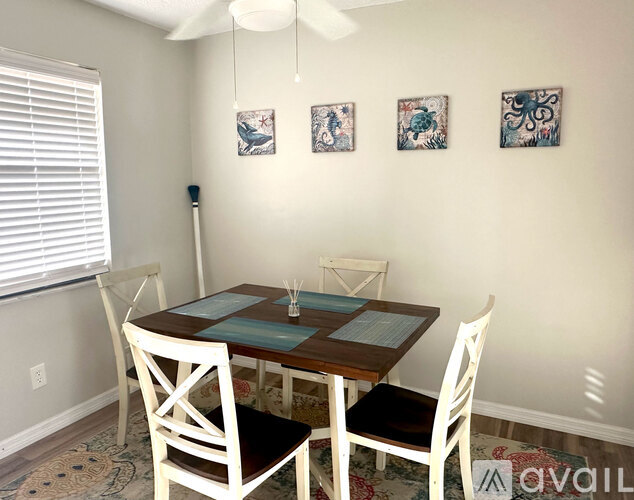A dining room with a table and chairs.