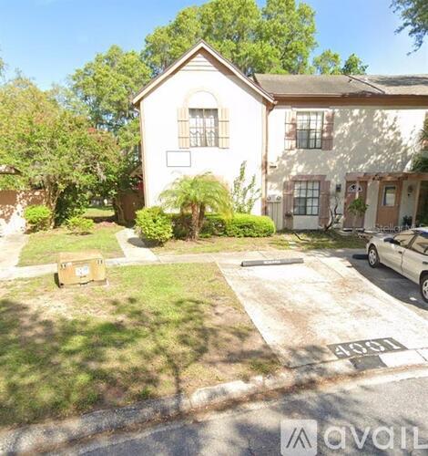 A house with a driveway and a car parked in front.