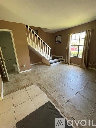 A living room with a staircase and a door.