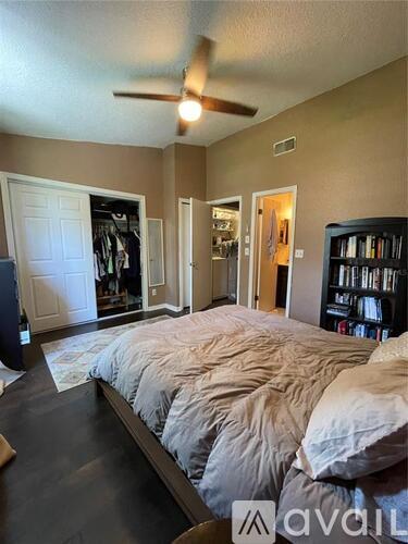 A bedroom with a large bed and a ceiling fan.