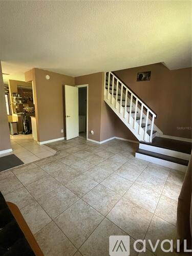 A living room with a staircase leading to the upper floor.
