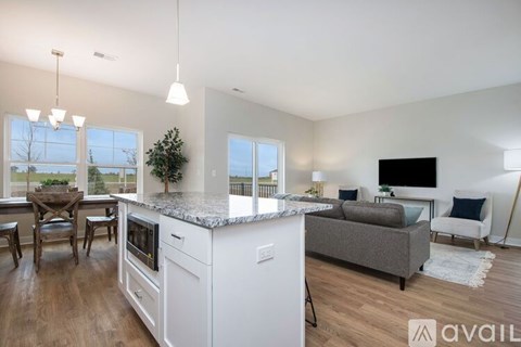 A modern kitchen with white appliances and a dining table with chairs.