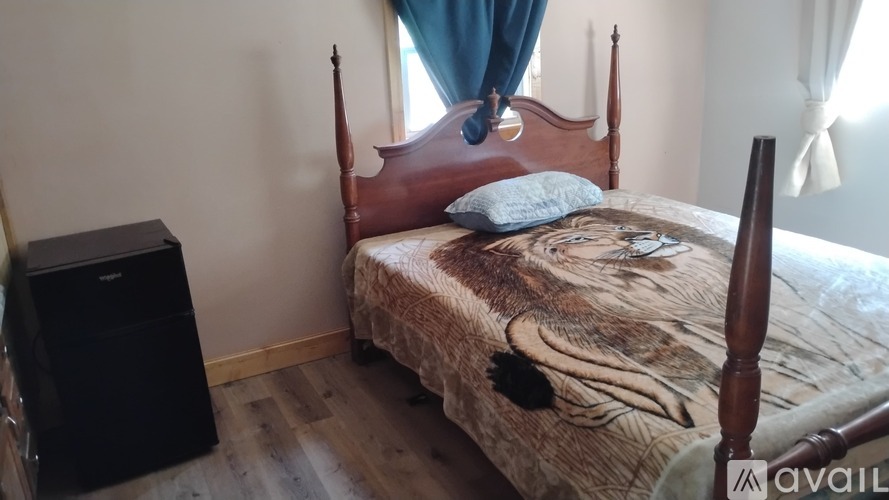 A bed with a wooden frame and a pillow with a black feather on it.