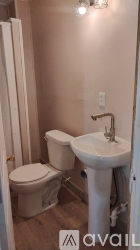 A white toilet and sink in a small bathroom.