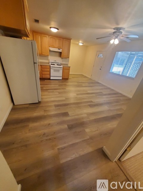 A kitchen with a white refrigerator and wooden cabinets.