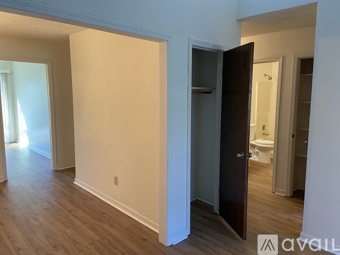 A room with a door leading to a bathroom.