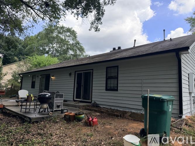A small house with a patio and a grill.