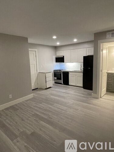 A kitchen with black appliances and white cabinets.