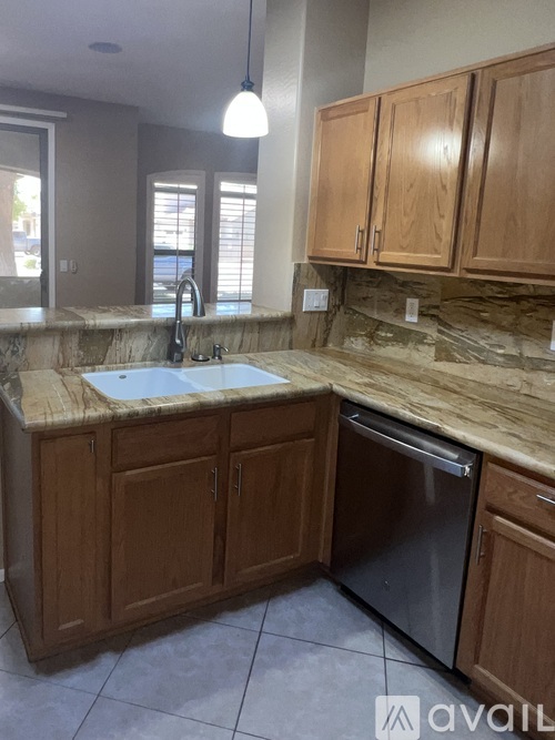 A kitchen with wooden cabinets and a granite countertop.