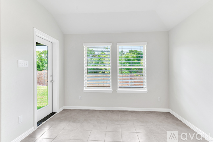 A room with two windows and a sliding glass door.