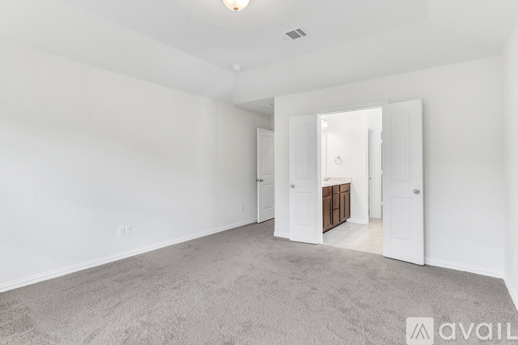 A spacious room with a carpeted floor and white walls.