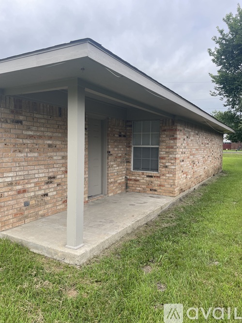 A small brick building with a porch and a door.