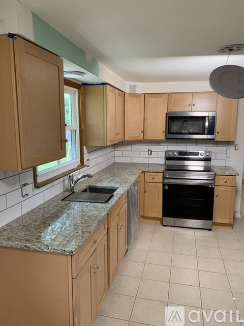 A kitchen with wooden cabinets and a granite countertop.