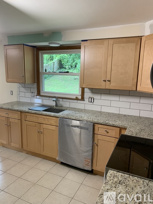 A kitchen with wooden cabinets and a granite countertop.