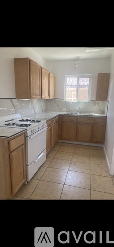 A kitchen with wooden cabinets and a white stove top oven.