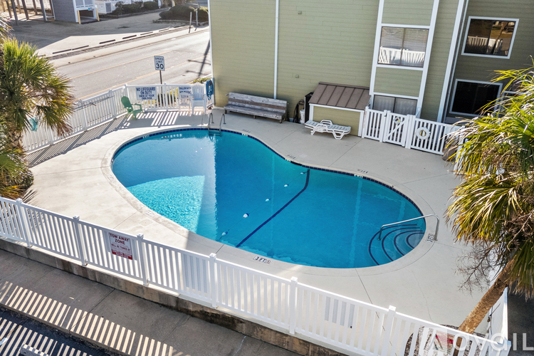A small pool surrounded by a white fence.