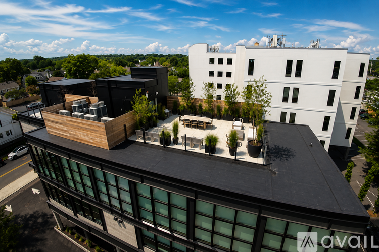 A modern building with a black and white exterior and a balcony with plants.