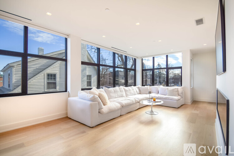 A living room with a white couch and a large window.