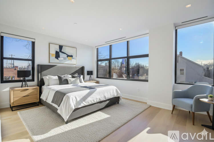 A bedroom with a large bed and a chair.