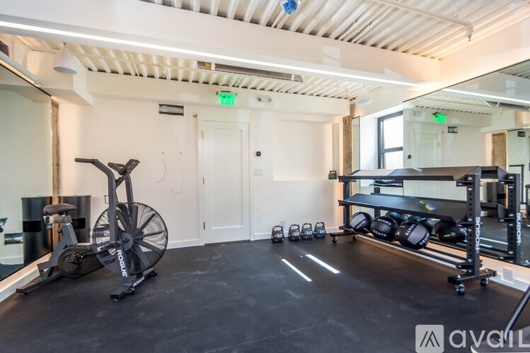A gym with a stationary bike, weights, and a mirror.