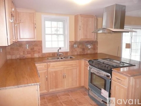 A kitchen with wooden cabinets and a stove top oven.