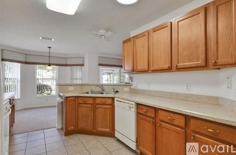 A kitchen with wooden cabinets and a white dishwasher.