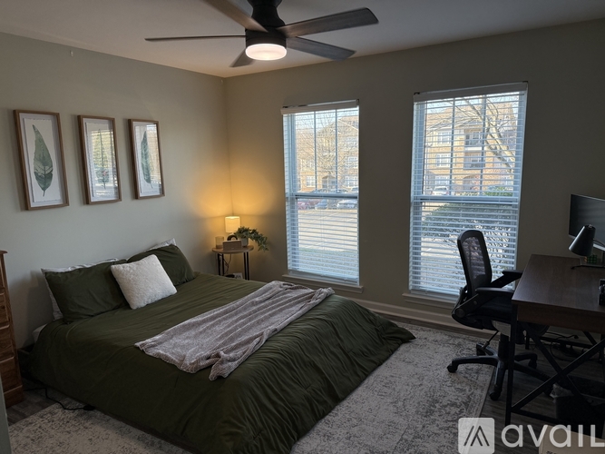 A bedroom with a bed, desk, and window.