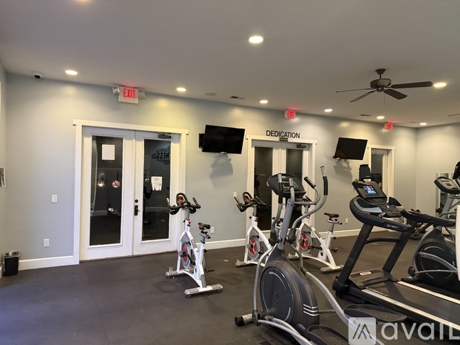 A gym with a row of exercise bikes and a sign that says "Dedication".
