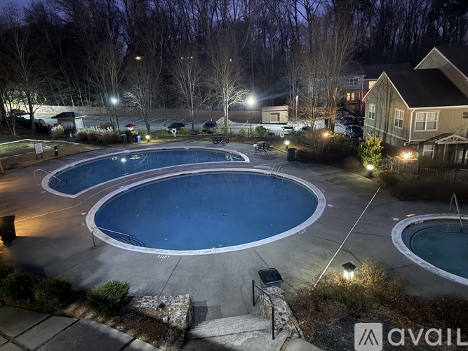A swimming pool at night with lights on.