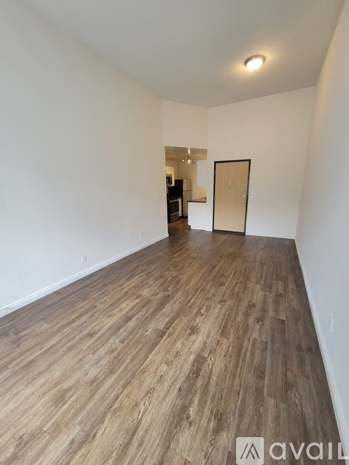 A room with wooden flooring and a white wall.