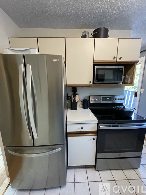 A kitchen with a stainless steel refrigerator and a white oven.