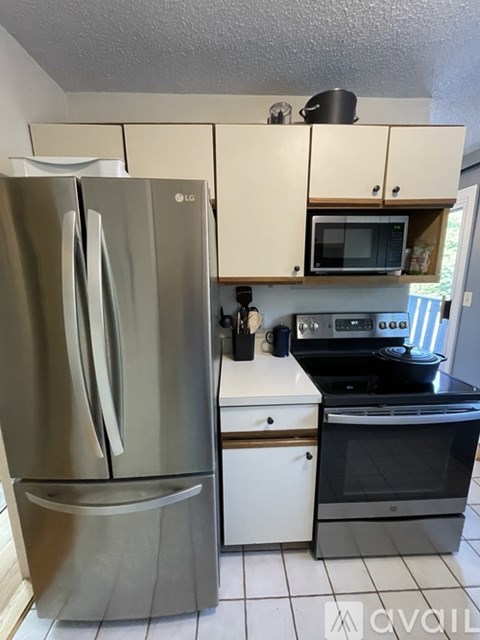 A kitchen with a stainless steel refrigerator and a white oven.