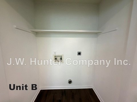 A white room with a J.W. Hunter Company Inc. sign and a Unit B sign.