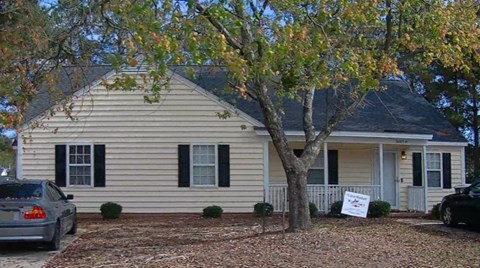 A house with a car parked in front of it.
