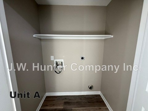 A small, empty room with a shelf and a door.