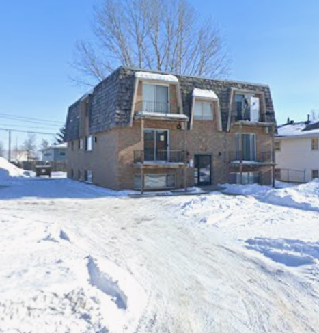 A house with a grey roof and a balcony covered in snow.