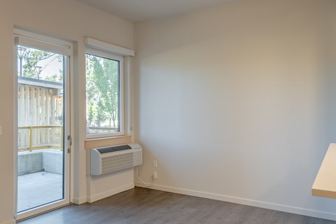 A room with a window and a wall-mounted air conditioner.