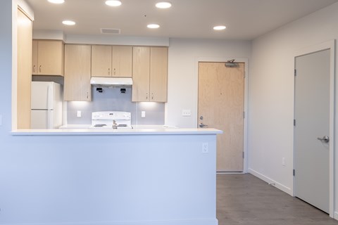 A kitchen with white countertops and wooden cabinets.