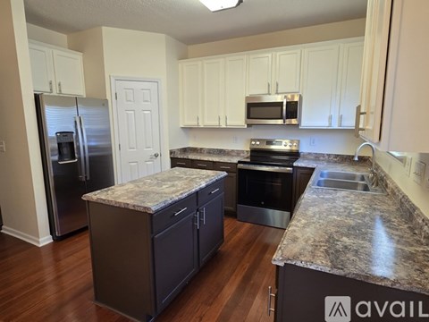 A kitchen with granite countertops and stainless steel appliances.