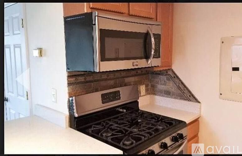 A kitchen with a stove top oven and a microwave above it.