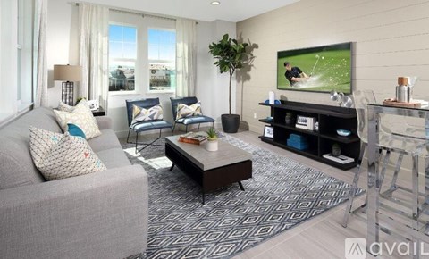 A living room with a grey couch, a coffee table, and a television playing a sports game.