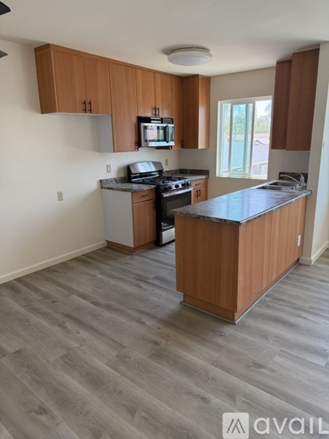 A kitchen with wooden cabinets and a grey countertop.