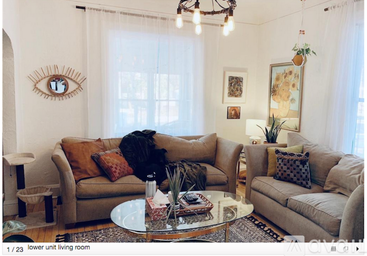 A living room with a couch, a coffee table, and a mirror on the wall.